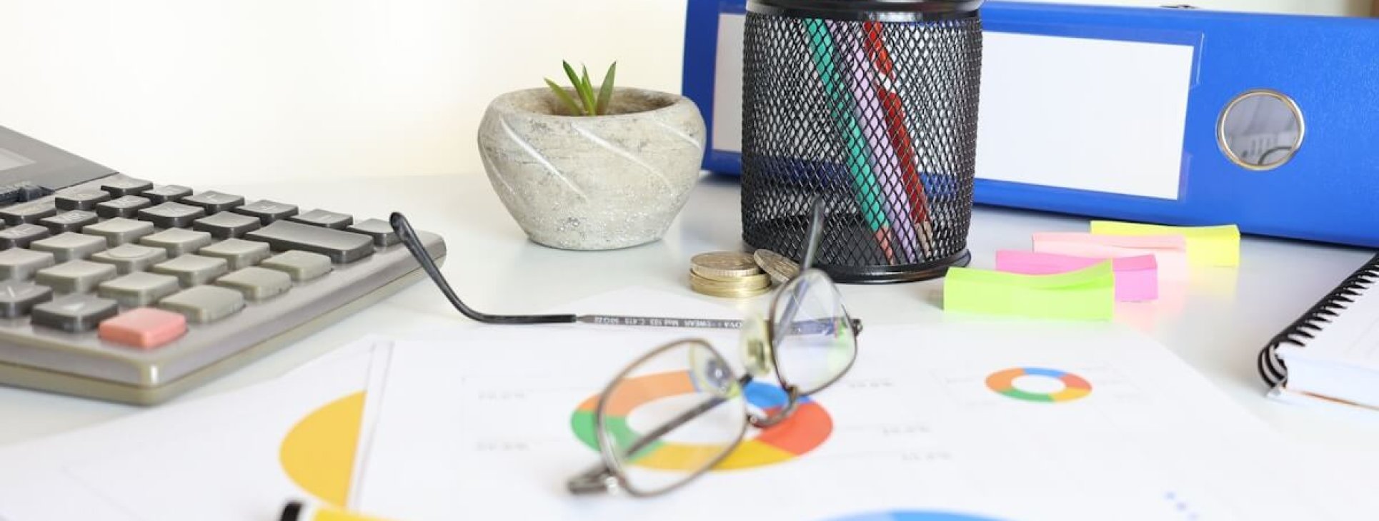 Financial analyst reviewing employer of record cost breakdown with calculator and charts