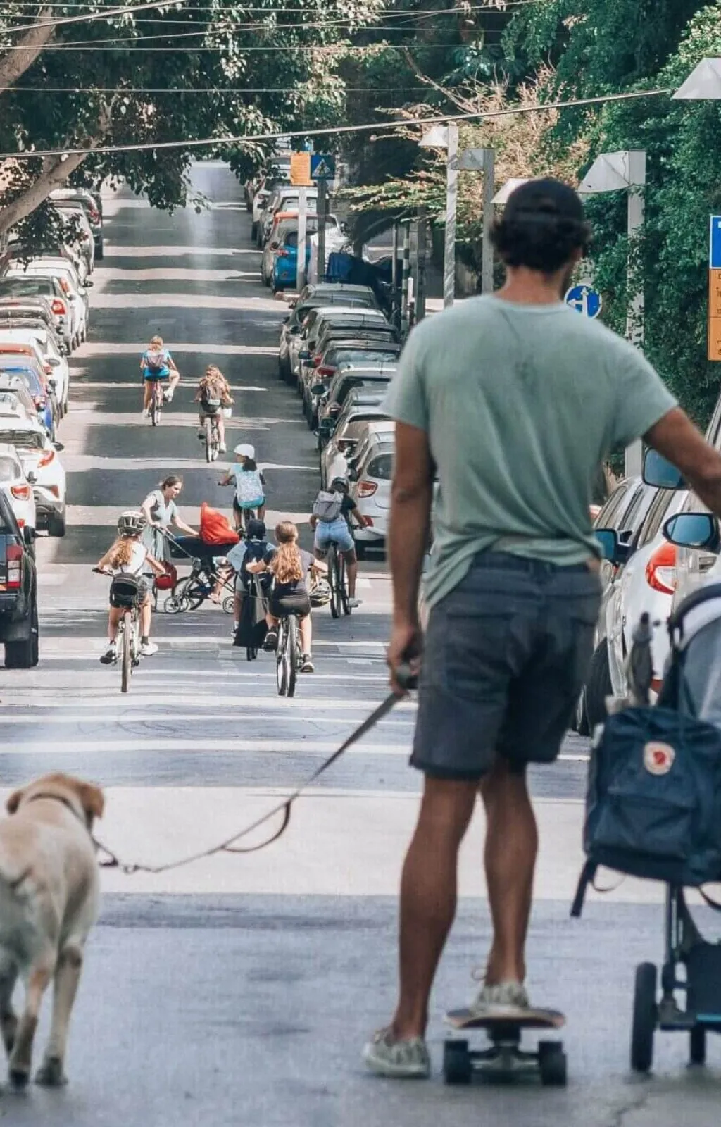 Man walking a baby and a dog whilst on a skateboard-yoav-aziz-unsplash